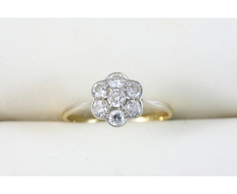 A DIAMOND CLUSTER RING set with circular-cut diamonds, in 18ct. gold. Size R.
