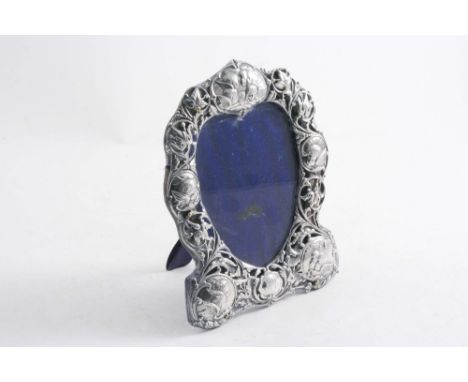A LATE VICTORIAN MOUNTED PHOTOGRAPH FRAME heart-shaped with a pierced & embossed border of leaves & cherub masks, easel stand