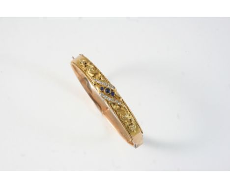 A GOLD, SAPPHIRE AND DIAMOND HALF HINGED BANGLE set with three graduated circular-cut sapphires and circular-cut diamonds wit