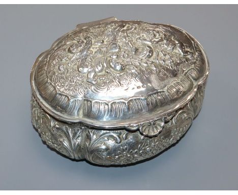 An early 20th century continental repousse silver oval trinket box, decorated with cherubs, import marks for London, 1928, 15