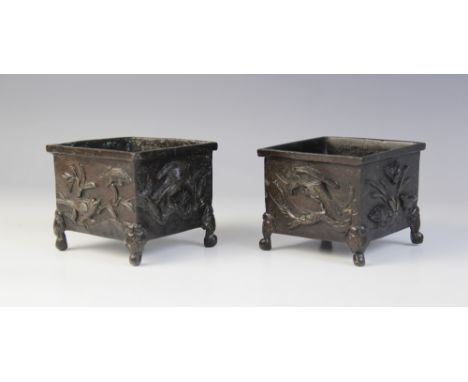 A pair of Japanese bronze cache pots, Meiji period (1868-1912), each of square form and relief decorated with birds in flight