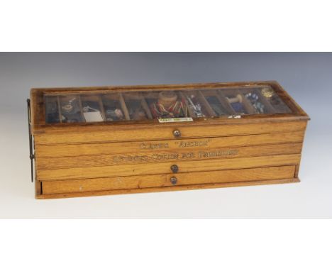 An oak haberdasher's table top display cabinet, early 20th century, comprising four sectioned trays joined by a brass concert