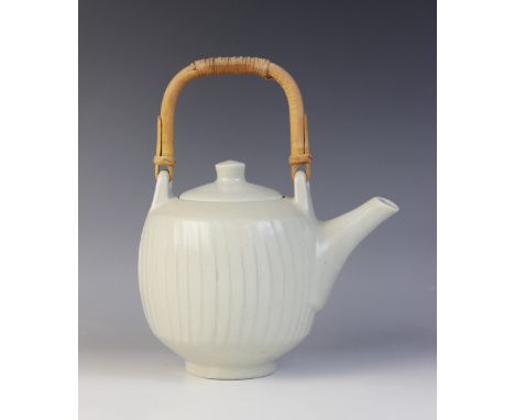 David Leach (1911-2005), a porcelain teapot with fluted cut-sided detail, celadon glaze and cane handle, "DL" impressed mark 