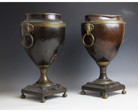 A pair of 19th century Adam style bronzed urns, of typical tapering form, with applied gilt metal rams mask ring handles upon