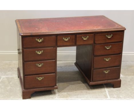 A George II mahogany twin pedestal desk, the rectangular moulded top inset with a gilt tooled red leather skiver, over a pair