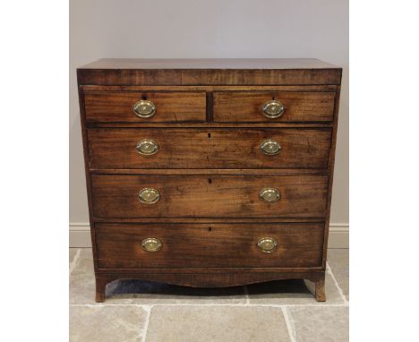 An early 19th century mahogany chest of drawers, the rectangular crossbanded top above an arrangement of two short and three 