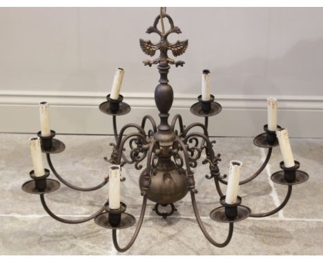 An early 20th century brass Dutch style eight branch light fitting, the central bulbous column with a cast eagle crest, exten