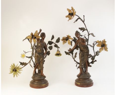 A pair of French Art Nouveau spelter figural table lamps, titled 'Muse des Bois' and 'Chant des Pres', each mounted on rouge 