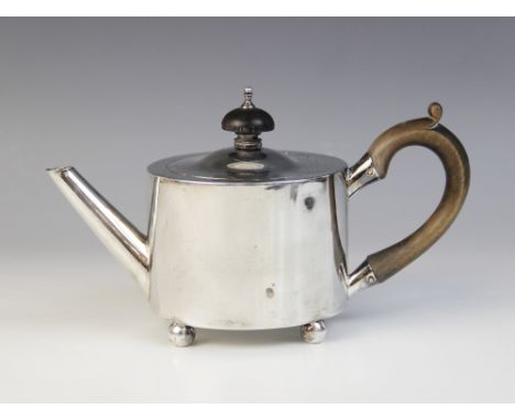 A George III silver bachelor?s teapot by William Troby, London 1812, of cylindrical form on four bun feet, hinged cover with 