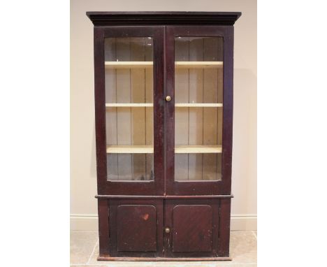 A Victorian stained pine kitchen cabinet, the moulded cornice above a pair of glazed doors opening to a painted interior, ove