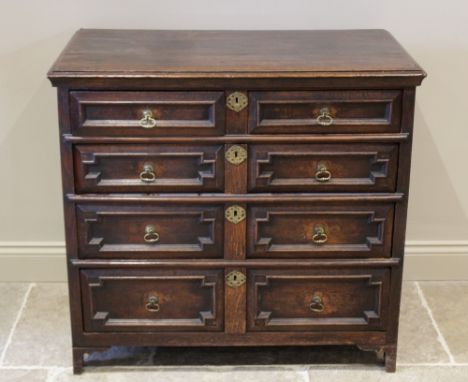 An early 18th century oak chest of drawers, the three plank moulded top above an arrangement of two short and three long geom