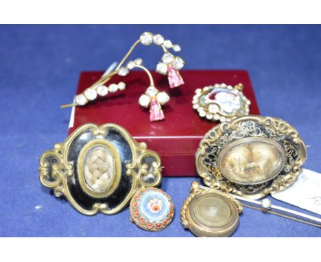 Two mourning brooches, one yellow metal with black enamel and leaf scrolls, hair panel to centre, the other gilt metal with b
