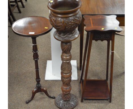 An Edwardian carved and inlaid two-tier plant stand; together with a reproduction mahogany wine table; and a heavily carved a