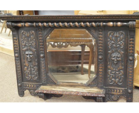 A 19th Century bevelled wall mirror with canted corners, in ornate heavily carved oak frame, with carved 'Greenman' panels, a