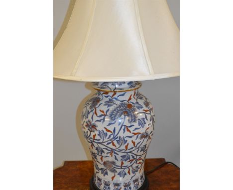 A table lamp, with oriental floral design, cream coloured shade.