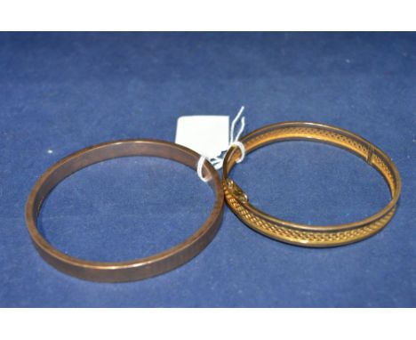 A 9ct yellow gold bangle with engine turned design, 12g; and a yellow metal bangle, with pierced design.