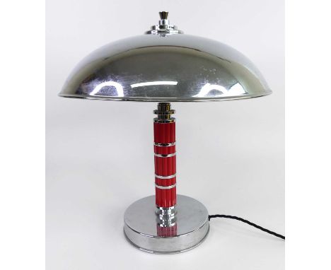 An Art Deco style chrome and red bakelite table lamp, having a plain domed shade to cluster banded column, h.40cmStands well.