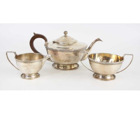 A matched Art Deco silver three-piece tea set, comprising; teapot, twin handled sugar bowl and cream jug, each of plain squat