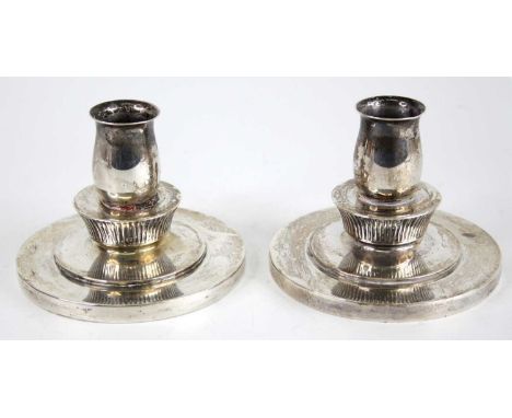 Evald Nielsen (1879-1958) - a pair of Danish silver candlesticks, of squat circular stepped form with bulbous sconce, the top
