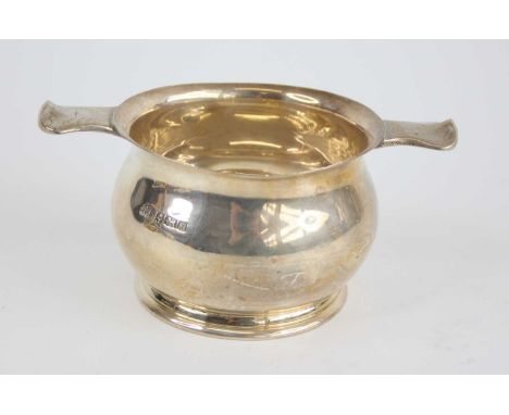 A 1960s silver quaich, of typical squat circular form, with a bulbous body and shaped strut handles to either side of the eve