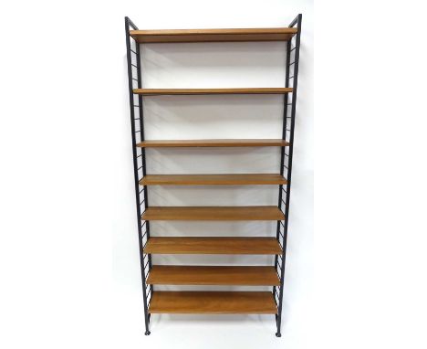 A 1970s Ladderax teak and black painted metal single open adjustable bookshelf, having eight shelves and sixteen conforming c