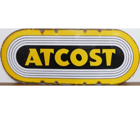 An enamel on metal advertising sign titled 'Atcost', with rounded ends and upper and lower affixing points, 30.5 x 76cm