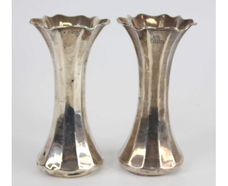 A pair of early 20th century silver fluted vases, each of faceted waisted form with shaped flaring rims, maker Thomas Bradbur