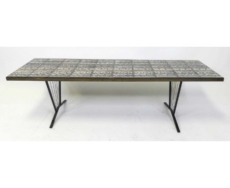 A 1970s tile topped rectangular long coffee table, the stylised banded tiles heightened in gilt, on painted steel and wirewor