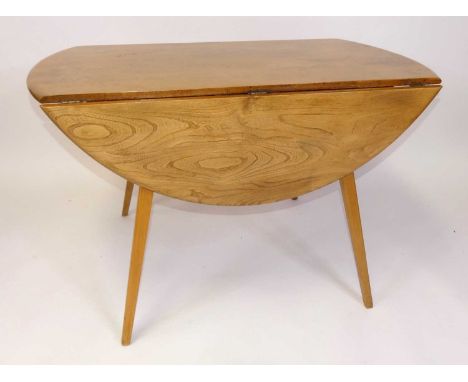 A 1960s Ercol blond elm Windsor 'Model 384' dropflap kitchen table, having opposing fall leaves, raised on slightly curved ta