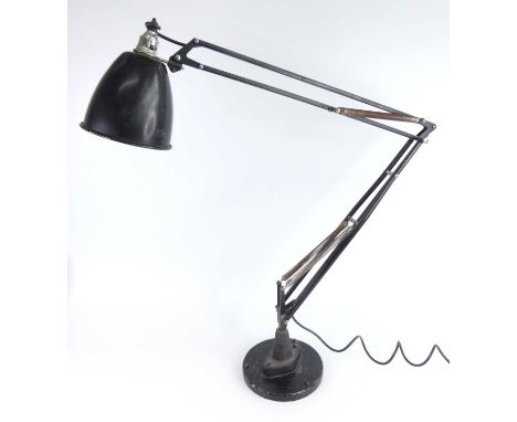 A 1940s anglepoise black painted metal desk lamp, with domed tilting shade and typical hinged branch arms, supported on integ