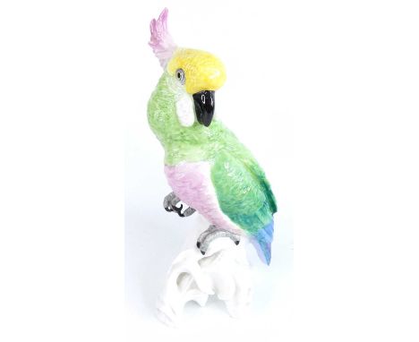 J.T. Jones - a large glazed ceramic model of a cockatoo, perched upon a naturalistic outcrop, bright colour painted in tones 