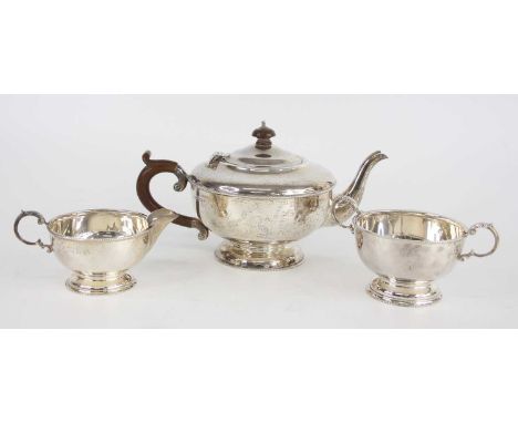An Art Deco silver three-piece tea set, comprising; teapot, cream jug and twin handled sugar bowl, each of squat circular for