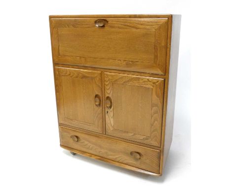 An Ercol blond elm Windsor 'Model 469' portable drinks cabinet, having fall-front compartment over twin cupboard doors to sin
