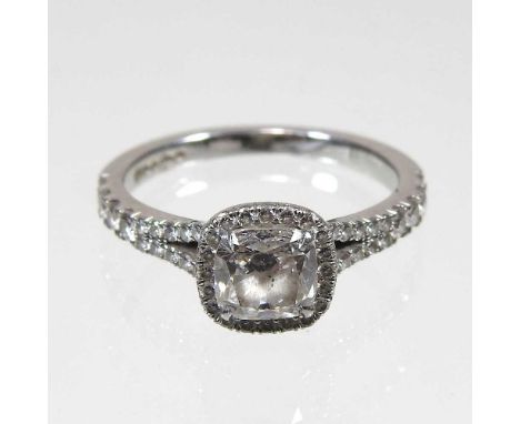 A platinum and diamond halo ring, the central brilliant cut stone approximately one carat, colour D, clarity SI1, surrounded 