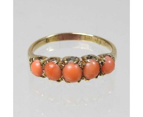 An 18 carat gold coral five stone ring, 2.6g, size P