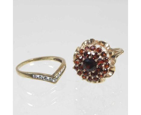 A 9 carat gold garnet set cluster ring, of tiered design, set within an openwork surround, 3.8g, size J, together with a 9 ca