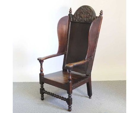 A 19th century and later carved oak armchair, with a panelled back, on bobbin turned supports