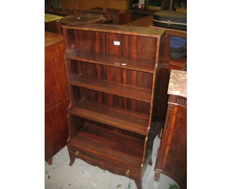 Rosewood four shelf waterfall bookcase having drawer to base with brass knob handles raised on splay supports, 24.5ins wide x