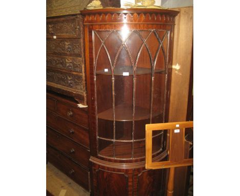 Reproduction mahogany bow fronted corner cabinet with a single glazed door above a pair of panel doors on bracket feet