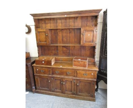 Good quality reproduction oak dresser in George III style, the boarded shelf back with cupboards and spice drawers, the base 