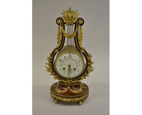 19th Century French amboyna and ormolu mounted lyre form mantel clock, the enamel dial painted with floral swags and with Ara
