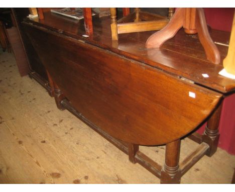 Reproduction oak wake style drop-leaf gate leg table on turned supports with stretchers together with a set of six hoop back 