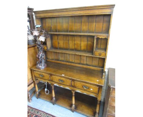 Good quality reproduction oak dresser with a boarded shelf back above three drawers, turned supports and undertier