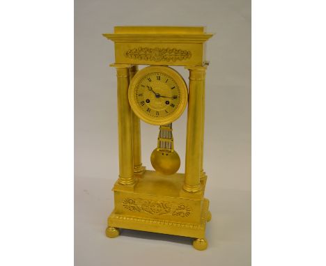 19th Century French Empire period matt gilded ormolu portico clock, the tooled gilt dial with Roman numerals, the two train m