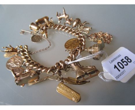 9ct Yellow gold charm bracelet with safety chain including a 1900 half sovereign and various charms including: St. Pauls Cath