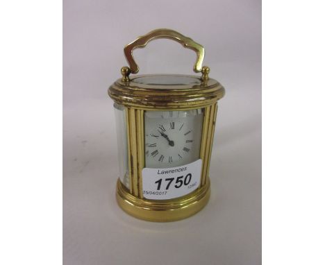 20th Century miniature oval gilt brass cased carriage clock with a single train movement, enamel dial and Roman numerals, 3in