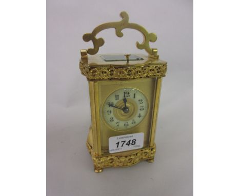 Small 19th Century French gilt brass carriage clock with serpentine case and floral adornments, the two train movement with h