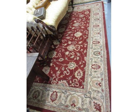 Machine woven Persian design carpet with medallion and floral design on a red ground, 11ft x 7ft approximately