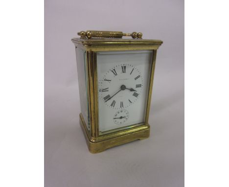 Early 20th Century brass cased carriage clock with enamel dial and Roman numerals, subsidiary alarm dial and two train moveme