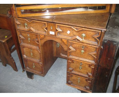 Late 18th / early 19th Century oak kneehole desk with seven geometric moulded drawers and central panelled door raised on lat